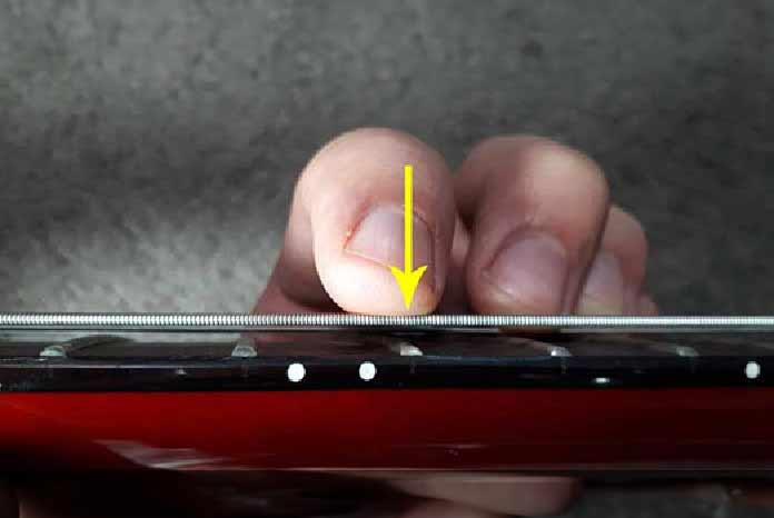 Adjusting string height on an electric guitar